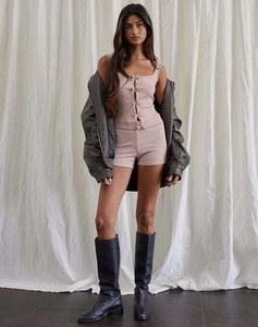 Detail of pink ribbed knit set with four bows, paired with grey jacket and black tall boots