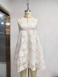 Detail of white halter neck dress featuring textured rose floral jacquard fabric