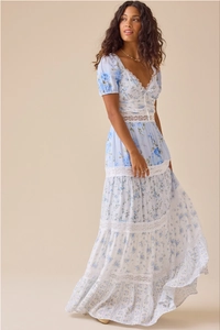 Close-up of white lace patchwork on a light blue floral V-neck midi dress with puff sleeves