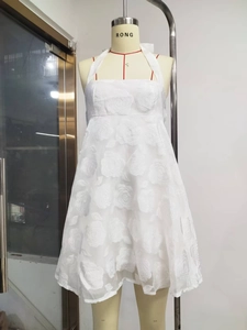 Close-up of white halter dress featuring elegant 3D rose floral jacquard fabric detail