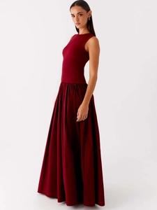 Elegant sleeveless dark red knit maxi dress with a pleated flowing skirt and crew neck