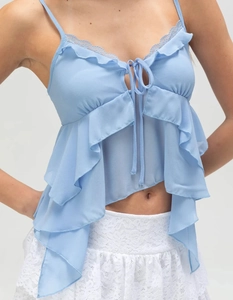 Dettaglio di canotta in chiffon azzurro con bordo in pizzo e orlo asimmetrico a balze