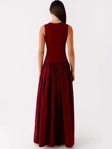 Back view of a burgundy sleeveless maxi dress with a ribbed bodice and pleated skirt