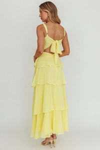 Detail of yellow backless tiered dress with gold metal rings and large bow tie accent