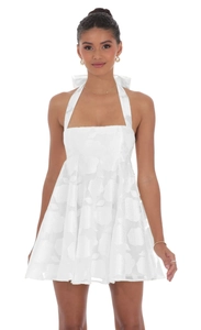 Detail of the white halter mini dress featuring intricate floral jacquard texture fabric