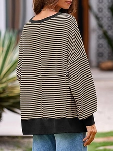 Détail de la texture en maille gaufrée et motif rayé noir sur sweat décontracté ample