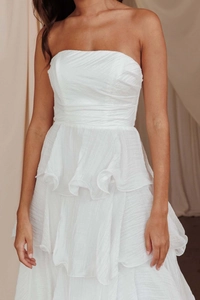 Dettaglio dell'abito bianco senza spalline a balze con eleganti strati in chiffon