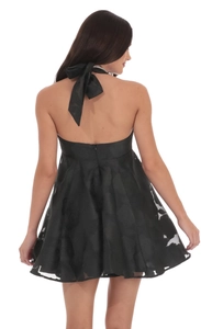 Close-up of the elegant backless black mini dress with butterfly bow and jacquard floral details