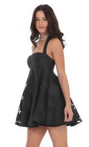Detailed macro view of the rose floral jacquard texture on a black backless dress