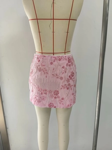 Detailansicht eines hellrosa Minirocks mit floralen Pailletten und Perlenstickerei