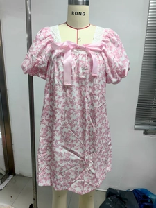 Detail of floral mini dress showing square neckline with lace trim and pink satin bow