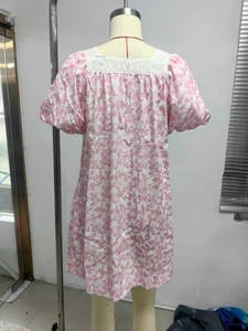 Detail of pink floral dress featuring white lace neckline and puff sleeve design