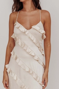 Detail of champagne satin dress with layered diagonal ruffles and silk texture finish