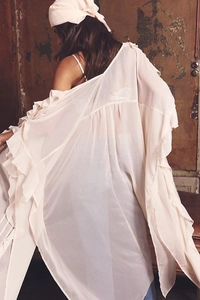 Detail of light pink sheer tulle cardigan with layered ruffles and bohemian aesthetic