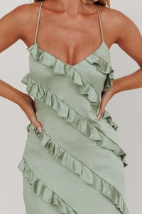 Detail view of sage green satin dress featuring tiered ruffles and delicate silk texture