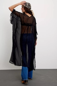 Detail of oversized sheer black chiffon cardigan with tiered ruffle cuffs for resort wear