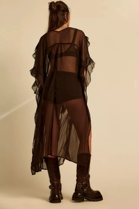 Detailed back view of sheer black blouse featuring oversized silhouette and ruffle trim