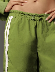 Detailed close-up of green lounge pants featuring lace side stripes and adjustable drawstring