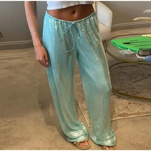 Détail du pantalon à paillettes bleu clair montrant la taille élastique à cordon