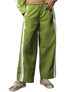 Detail of green wide-leg pants featuring white stripes and delicate lace trim