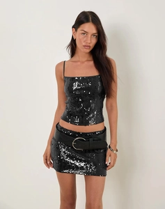 Détail d'un ensemble deux pièces en sequins noirs avec fines bretelles et large ceinture