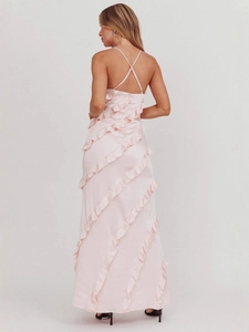Pink satin maxi dress featuring crisscross back straps and elegant ruffled wavy edges