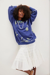 Detail of loose fit dark blue sweatshirt with light green ocean life and wave print