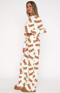 Close-up of Halloween pajamas set with festive pumpkin and ghost prints on soft white fabric