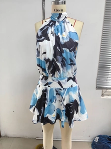 Detail eines Nackenträgerkleides mit blau-weißem Blumenmuster und einer taillierten Silhouette