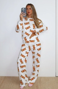 Detail of white pajamas featuring festive orange BOO pumpkin prints on soft long sleeves