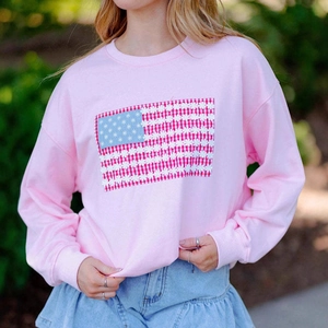 Gros plan d'un sweat rose à col rond avec motif drapeau américain en marguerites
