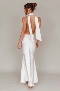 Dettaglio del retro di un abito in raso bianco con scollo a V profondo e lunghi nastri eleganti