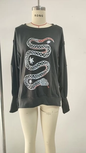 Detail of snake print with red stripes and white stars on dark grey crewneck sweatshirt