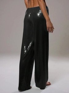 Détail d'un pantalon large à paillettes noires avec cordon de serrage pour fêtes
