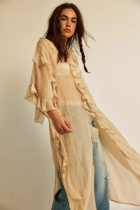 Detail of bohemian sheer beige long blouse with layered ruffle sleeves and flowy texture