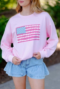 Détail du sweat rose à col rond avec imprimé drapeau US floral et jupe en jean à volants