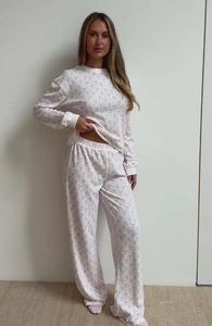 Detail of soft cream pajamas set featuring pink bow prints and ribbed knit texture