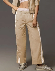 Detailed close-up of khaki wide-leg sweatpants with white side stripe and drawstring waist