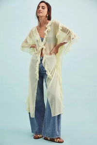Detailed view of layered ruffles and sheer fabric on a lime green vacation cover-up