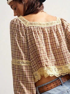 Close-up of yellow plaid blouse with delicate lace trim on hem and sleeves