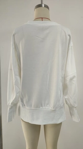 Detail view of the back of a loose white long-sleeve sweatshirt with ribbed hem and cuffs