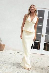 Detail of light yellow satin dress featuring delicate lace trim on the V-neckline