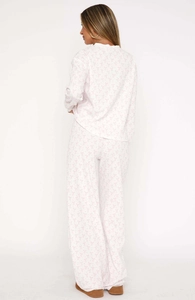 Detail view of white pajama set with pink bow pattern and textured waffle fabric