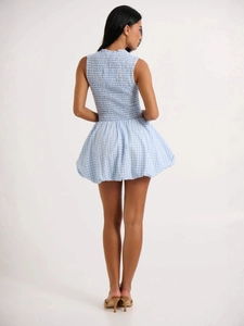 Robe courte vichy bleue avec bustier froncé au dos et ourlet volanté sur fond blanc