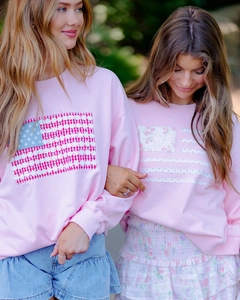 Vue détaillée des pulls roses avec drapeau américain et motifs patchwork de fleurs