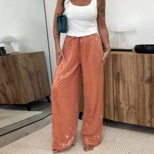 Détail du pantalon large à paillettes orange avec taille élastique et cordon de serrage