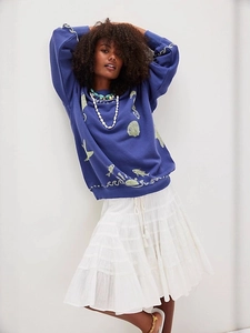 Navy crewneck sweater with sea life print and white layered maxi skirt for casual style