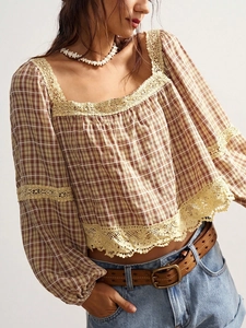 Detail of plaid blouse showing intricate lace trim and vintage checkered fabric pattern