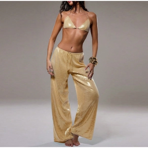 Détail de paillettes dorées haute densité sur un pantalon large à taille haute