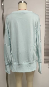 Rear view of light blue sweatshirt with drop shoulders and decorative raw seam stitching